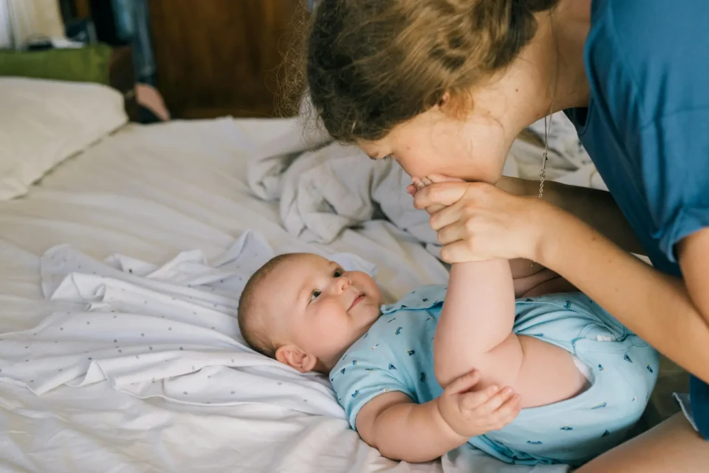 Mum kissing babys foot
